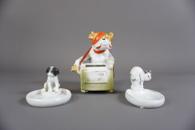 trois figurines représentant un chien et un chien assis sur une chaise