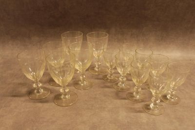 six verres à vin vides posés sur une table devant un fond marron