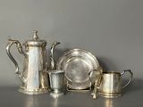 a silver tea pot, a silver plate, a silver cup, and a silver plate