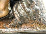 a bronze statue of a woman with a flower in her hand