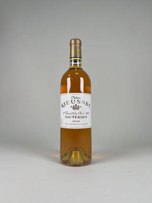 the bottle of wine is sitting on a white surface