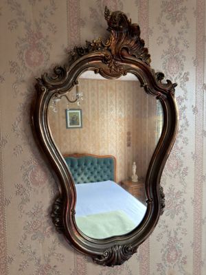 a mirror on the wall above a bed in a room