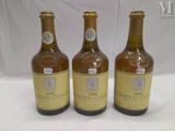 three bottles of wine are sitting on a white surface