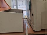 a white cat sitting on a table in front of a toaster oven