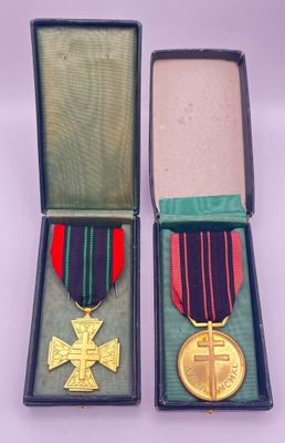 two medals in a box with a ribbon and cross on it