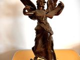 une statue représentant un ange tenant un chat sur une table