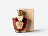 a bottle of brandy sitting next to a box on a white surface