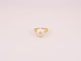 une bague en or avec une perle au centre
