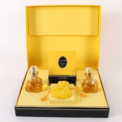 une image représentant une boîte jaune contenant deux flacons de parfum et une pochette
