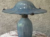 une lampe bleue posée sur une table recouverte d'une nappe rouge et blanche