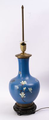 un vase bleu orné de fleurs, posé sur une table