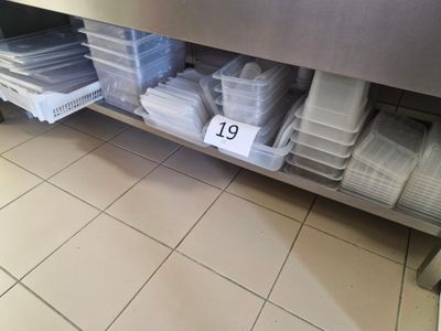 a lot of plastic containers on a shelf in a kitchen