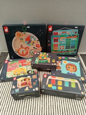 Plusieurs puzzles et jeux de réflexion pour enfants sont posés sur une couverture rayée.