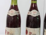 three bottles of wine are lined up on a white surface