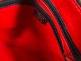 the inside of a red purse with a zipper on it