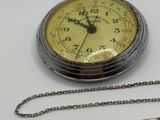 a silver pocket watch and a chain on a table