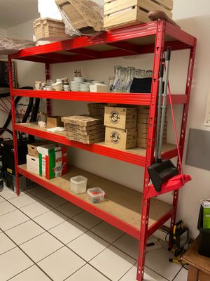 une étagère rouge sur laquelle sont posées des boîtes, dans une pièce