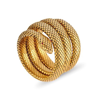 un gros plan d'une bague en forme de serpent en or sur fond blanc