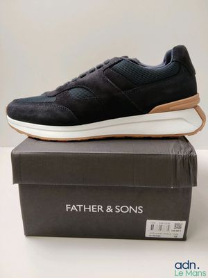 a pair of black sneakers sitting on top of a box