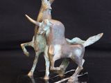 a bronze statue of a man riding a bull on a marble base
