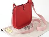 a small red bag with a pink strap on it