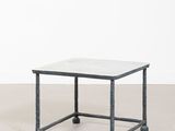 une table basse au plateau en marbre blanc, avec des pieds en métal noir