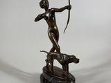 an image of a bronze statue of a woman with a bow and a dog