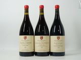 trois bouteilles de vin rouge sont posées sur une surface blanche