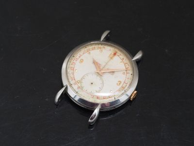 a silver watch with a white face on a black surface