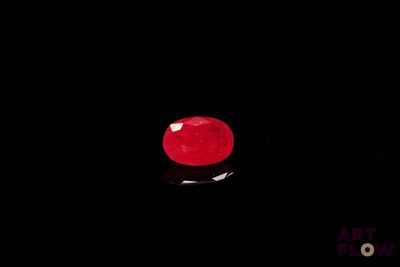 une pomme rouge posée sur une surface noire