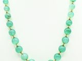 a green jade beaded necklace on a mannequin