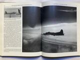 an open book with a picture of a plane flying in the sky