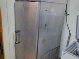 a silver refrigerator in the corner of a room