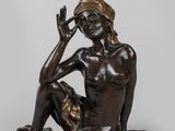 statue en bronze représentant une femme assise par terre, la main sur le visage
