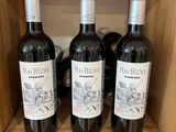 trois bouteilles de vin rouge se trouvent sur une étagère dans un magasin