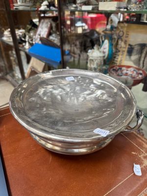 a metal bowl sitting on top of a wooden table