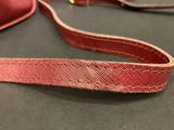 a red strap on a red bag on a table