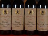 three bottles of red wine are lined up on a table