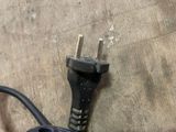 a black power cord plugged into an electrical outlet