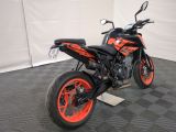 a black and orange motorcycle parked in a garage