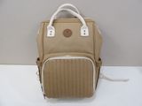 un sac à dos beige posé sur une table blanche