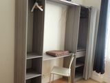 a bedroom with a bed and a desk with a television on it