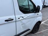 a white van parked in a parking lot next to a building
