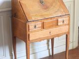 un petit bureau en bois avec un miroir accroché au mur