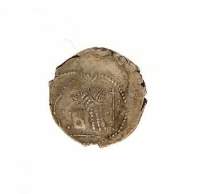 une vieille pièce de monnaie sur laquelle figurent un homme et un chien