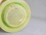 une personne tenant un gobelet en plastique muni d'un couvercle vert