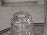 a clear glass bottle sitting on top of a silver tray