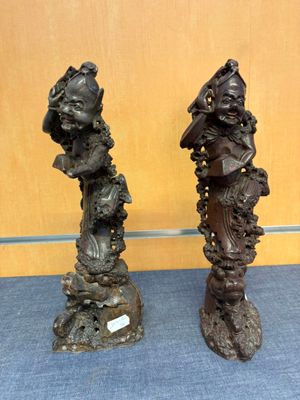 deux statues en bronze représentant une femme et un homme, posées sur un socle