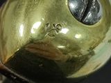 a close up of a gold colored object on a black surface