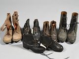 Plusieurs paires de bottes sont alignées sur une surface blanche